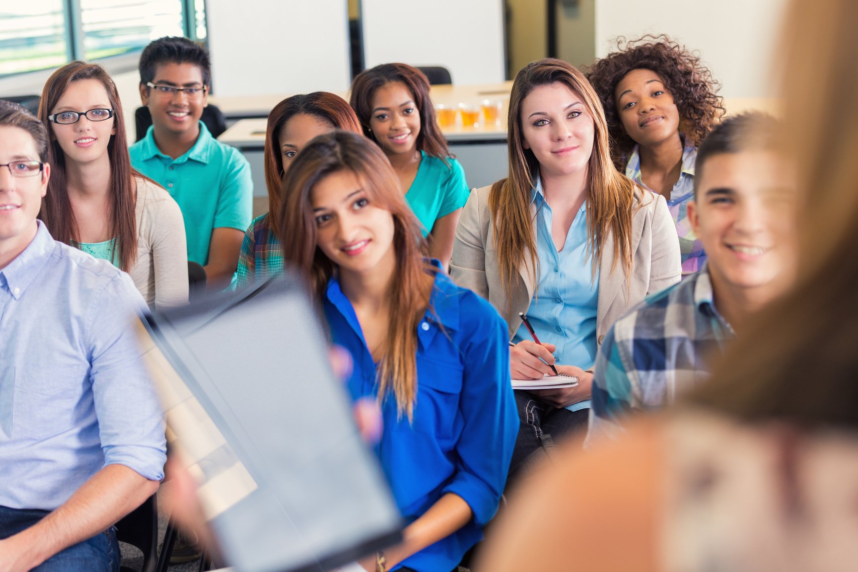 Diverse group of college students in lecture or orientation meeting