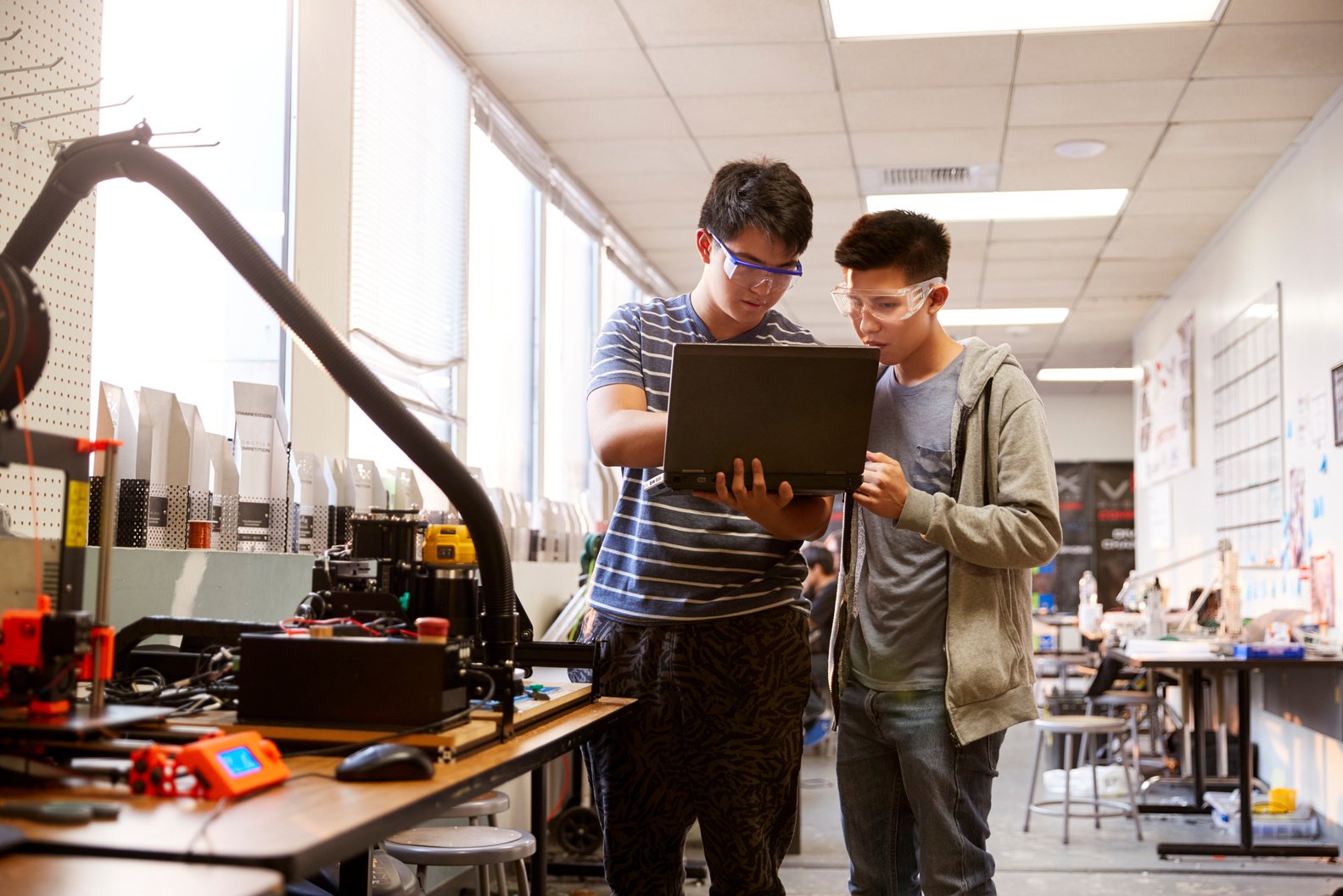 Two Male College Students Using Laptop Computer in Science Robot